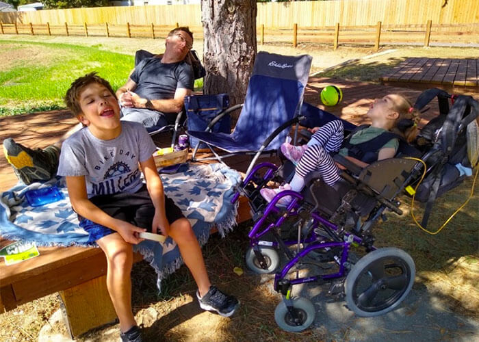 Kids napping near a tree.