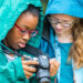 Two girls looking at a camera's screen.
