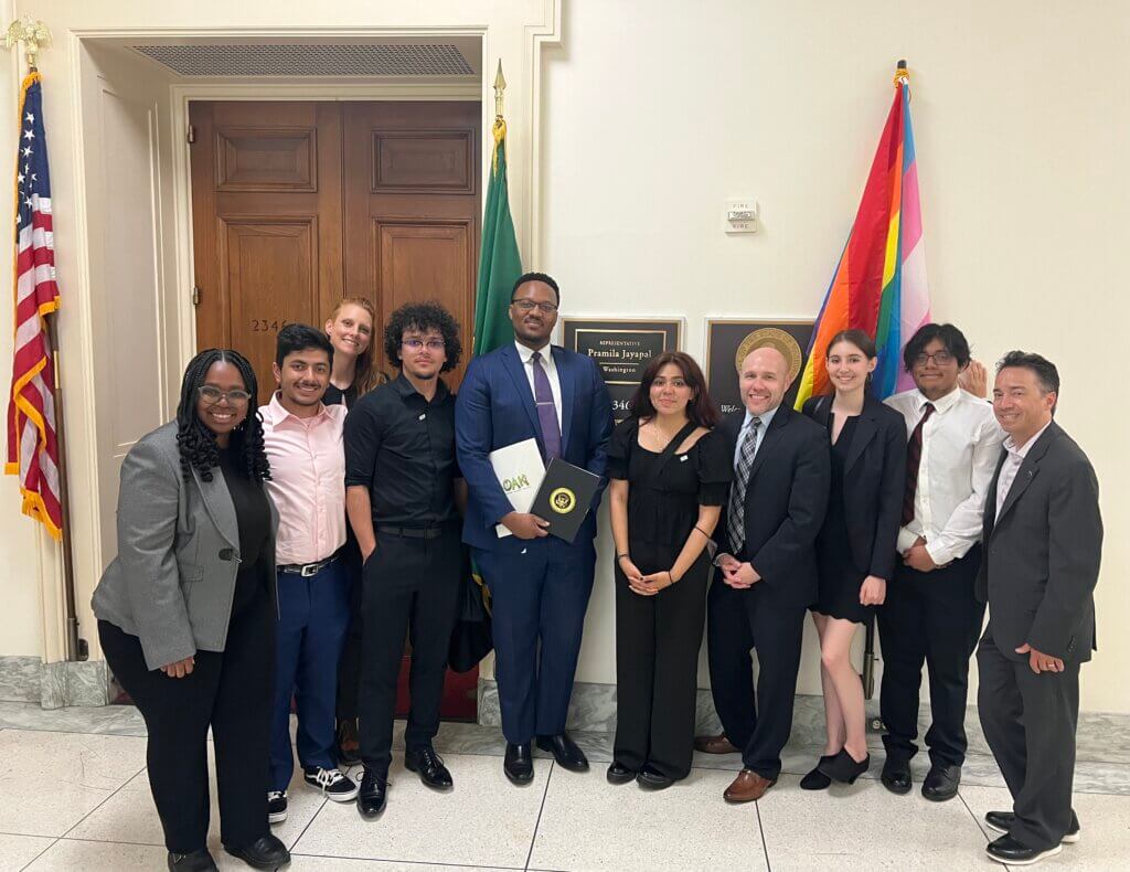 Ten people in business attire pose during OAK Week 2024.