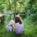 child with dog on grassy path in the woods